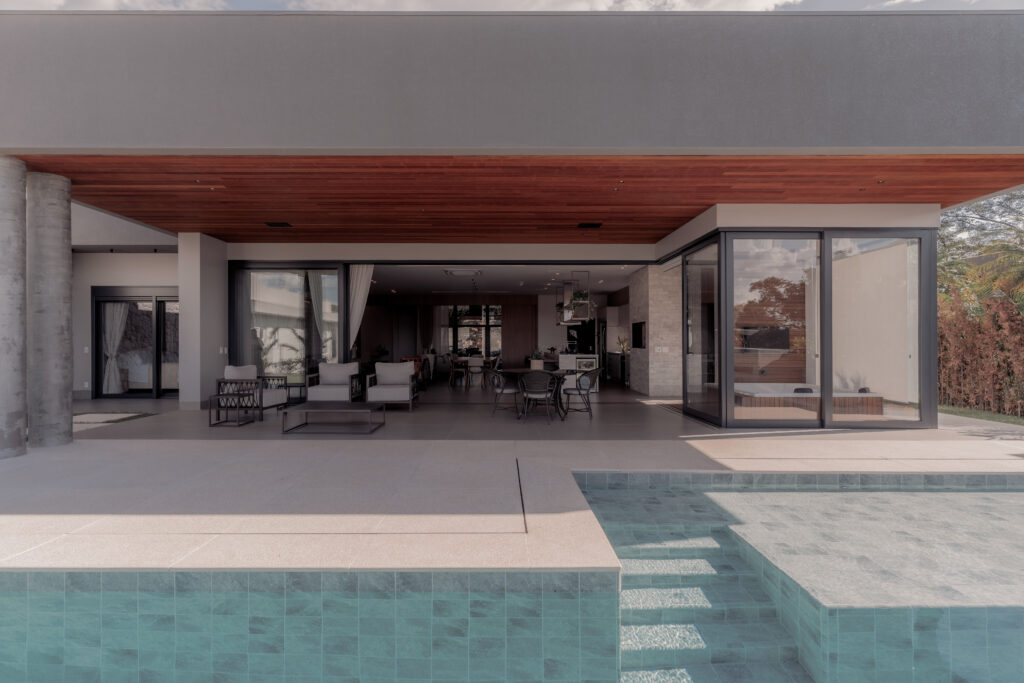 Grandes esquadrias Laguna conectando interiores, varanda e piscina na Residência Nexo